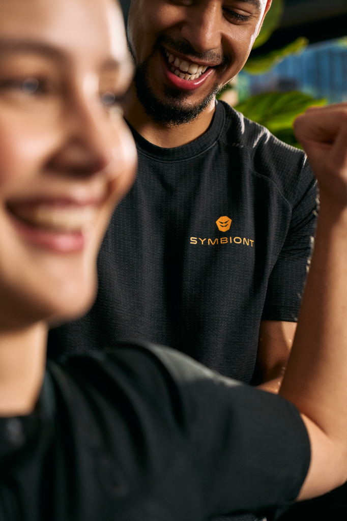 Close-up of a client and personal trainer discussing fitness and training goals at a local EMS studio for the best SYMBIONT training experience.